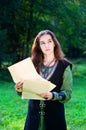 Young girl in medieval suit with old papers