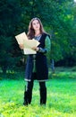 Young girl in medieval suit with old papers