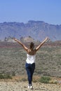 Young girl in the middle of the desert with a view of some beaut