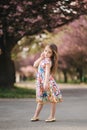 Young girl model poses to photographer. Female kid i beautiful dress outside