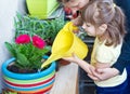 Young girl and mother watering potted flower plant smiling Royalty Free Stock Photo