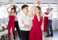 Young girl with multinational group of active people dancing couple enjoying active swing during dance party in ballroom Royalty Free Stock Photo