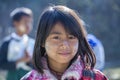 A young girl from Myanmar with Tanaka on her face in yard near local school, Burma