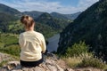 Young girl in the nature. Back view portrait of a single woman watching the Spajici lake from the height in west Serbia Royalty Free Stock Photo
