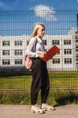 Young girl near school fence. Royalty Free Stock Photo