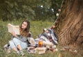 A young girl near a tree reading a book Royalty Free Stock Photo