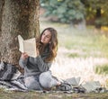 A young girl near a tree reading a book Royalty Free Stock Photo