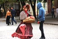 Young girl in old-fashioned dress sells candy from the tray