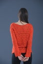 Young girl in orange handmade knitted blouse in studio