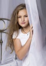 Young girl outstretching her arms sitting on the bed after good night sleep, back view Royalty Free Stock Photo