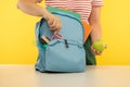 Young girl packing blue backpack. Back to school concept