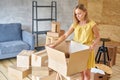 Young girl packing plates into the boxes ready to move. Woman unpacking moving boxes in her new home. unpack personal Royalty Free Stock Photo