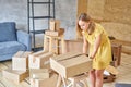 Young girl packing plates into the boxes ready to move. Woman unpacking moving boxes in her new home. unpack personal Royalty Free Stock Photo