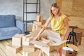 Young girl packing plates into the boxes ready to move. Woman unpacking moving boxes in her new home. unpack personal Royalty Free Stock Photo