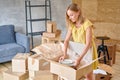 Young girl packing plates into the boxes ready to move. Woman unpacking moving boxes in her new home. unpack personal Royalty Free Stock Photo