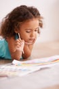 Young girl, painting and brush on floor with paper, creativity and drawing for learning or childhood. Toddler, motor Royalty Free Stock Photo