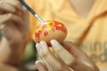 Young girl painting Easter eggs in hand. April spring season and Easter holiday creative activity