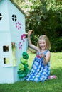 Young Girl Painting Home Made Cardboard House