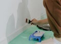 A young girl paints a wall with a brush. Royalty Free Stock Photo