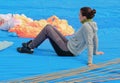 The young girl-parachutist sits on a blue fabric