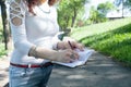 Young girl in the park makes entries in the diary