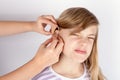 Young girl patient not too happy while hands inserting a hearing Royalty Free Stock Photo
