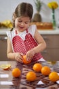 Little girl peeling oranges