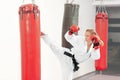 Young girl performing martial arts high kick boxing heavy bag. Royalty Free Stock Photo