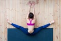 Young girl performing wide-angle seated forward bend or upavistha konasana during stretching class in gym