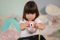 Young girl photographer make photo of her toy camera. Cute little girl play at home Royalty Free Stock Photo