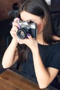 Young girl photographer with old analog camera in cafe Royalty Free Stock Photo