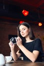 Young girl photographer with old analog camera in cafe Royalty Free Stock Photo