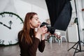 Young girl photographer shooting on studio. Professional photographer on work Royalty Free Stock Photo