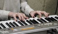 A young girl pianist plays the electronic piano with her favorite music. Female graceful hands touch the keys of the synthesizer c Royalty Free Stock Photo