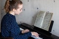 Young girl pianist in the process of playing the piano. Plays classical music. Lifestyle Royalty Free Stock Photo