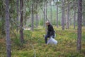 A young girl picks blueberries in a Finnish forest using a Thai comb tool Royalty Free Stock Photo