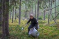 A young girl picks blueberries in a Finnish forest using a Thai comb tool Royalty Free Stock Photo