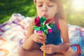 Young girl, picnic and blowing pinwheel, garden and enjoying freedom of outside and happy. Colourful little child Royalty Free Stock Photo