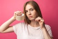 Young girl on pink background Holding a piece of stickytape, with serious face, photo Studio, cute and beautiful Royalty Free Stock Photo