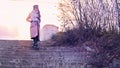 A young girl in a pink coat goes down the stairs in the park on autumn sunny evening. Stock footage. Retro landscape Royalty Free Stock Photo