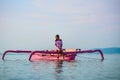 A young girl in a pink sundress and in a pink boat on the sea background Royalty Free Stock Photo