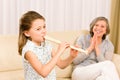 Young girl play flute with proud grandmother Royalty Free Stock Photo