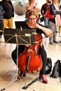 Young girl playing the cello in an orchestra on the street Royalty Free Stock Photo