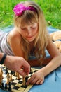 Young girl playing chess outside
