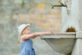 Young girl playing in drinking water fountain in Lucca city, known for its intact Renaissance-era city walls and well preserved Royalty Free Stock Photo