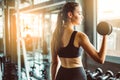 Young girl playing dumbbell to exercise in fitness.Slim girl lifts heavy dumbbell while training in the gym. Sports concept fat b Royalty Free Stock Photo