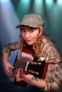 Young girl playing guitar on the stage