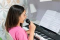 Young girl playing piano and singing at home Royalty Free Stock Photo