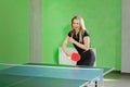 Young girl playing ping pong. athlete kicks the ball with a tennis racket Royalty Free Stock Photo