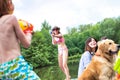 Young girl playing squirt guns with her brother on pier during summer Royalty Free Stock Photo